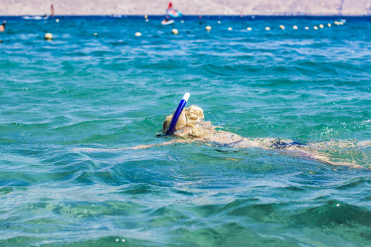 summer vacation and sea activities concept picture of swimming snorkeling girl with mask and tube and looking under water, copy space for text