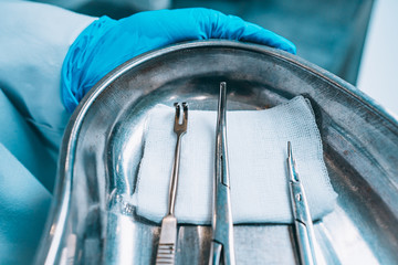 Several surgical instruments lie on a tray