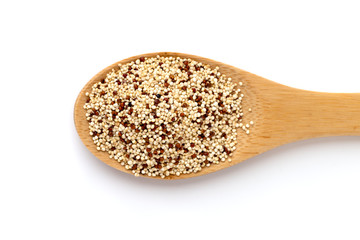 Quinoa in a spoon close-up. Quinoa in a wooden spoon on a white background.
