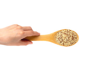 Quinoa in a spoon close-up. A spoon with a quinoa in hand on a white background.