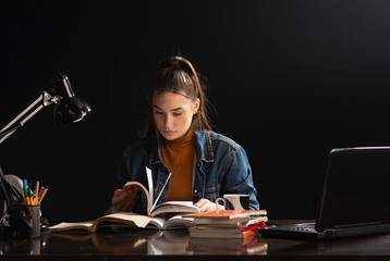 The girl is sitting at the table and study