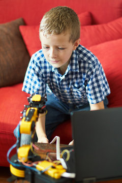 Boy is learning how to program a robot