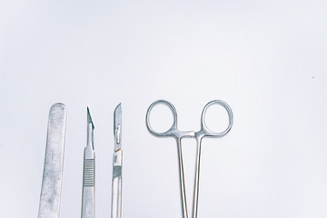 Scapula for throat, two scalpels and clamp on a light background