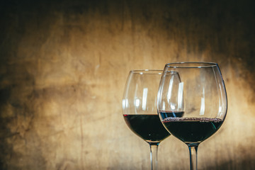 Red wine in glasses on rustic background, copy space