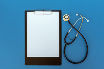 Stethoscope and clipboard on blue background, health and medical concept