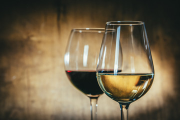 Red and white wine in glasses on rustic background, copy space