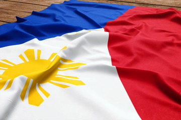 Flag of Philippines on a wooden desk background. Silk Filipino flag top view.