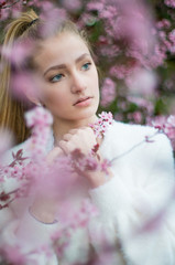 Portrati of a teen girl standing in a bunch of pink flowers, shot shallow depth of field.