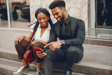A stylish and beautiful dark-skinned couple in a city