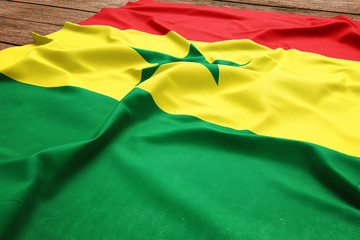 Flag of Senegal on a wooden desk background. Silk Senegalese flag top view.
