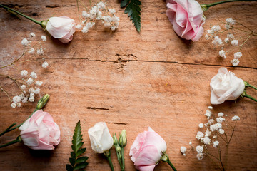 Rosa und weiße Blumen auf Holz liegend