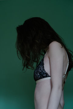 Portrait of anonymous skinny female model in underwear from behind
