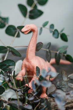 Pink dinosaur stands in forest