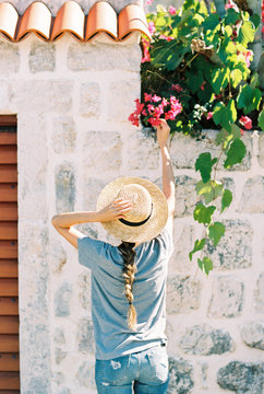girl from the back reaching out pink bougainvillea