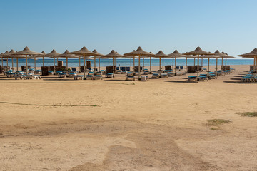 background of a deserted , abandoned beach with sunbeds, umbrellas overlooking the sea
