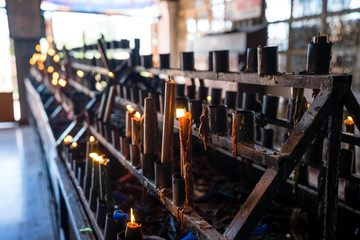 Multicolored lighted candles in church 