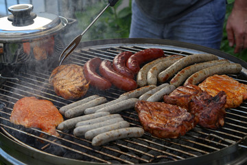 Meat and sausages are fried on the grill
