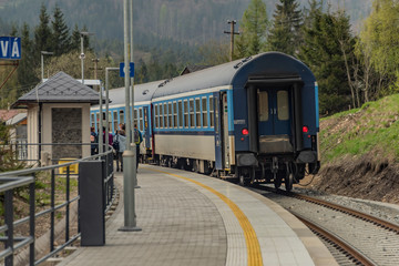 Blue diesel train with passengers coach in Jeseniky mountains