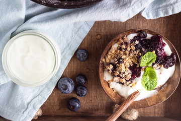 Oatmeal crumble in cast iron pan with fresh blueberry and natural yogurt. Healthy food concept. 