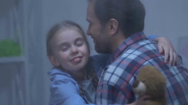 Attentive father hugging cute little girl, happy family spending time together