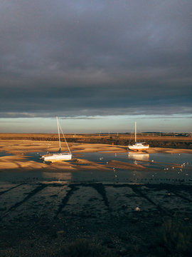 Low tide and boats at sunset. Wells-next-the-sea, Norfolk, UK.