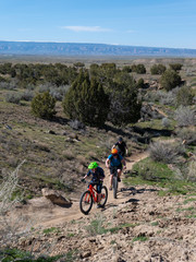 Son, mother and grandfather riding mountain bikes of singletrack in Colorado