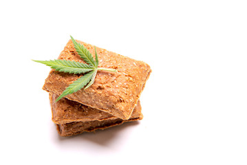 Dog treats and cannabis leaves isolated over white background - CBD and medical marijuana for pets concept