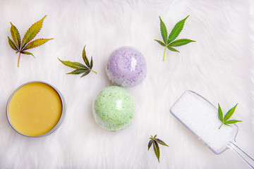 Assortment of cannabis topicals with bath bombs and marijuana salve over white