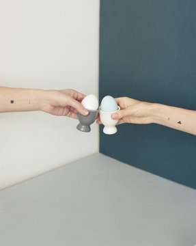 Hands clinking eggs in cups
