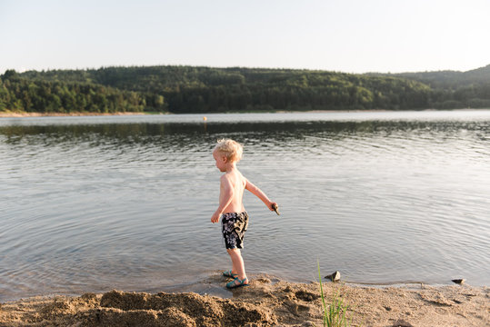 little boy at the beach by a lake