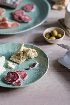 A european inspired lunch of baguette, cheese, charcuterie, olives and anchovies.