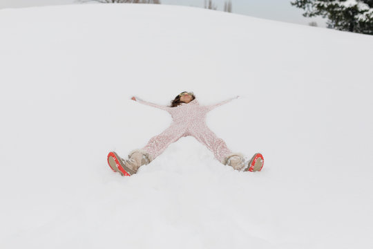 Beautiful woman lies  in the snow wearing onesie