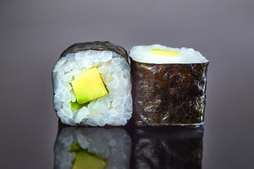 Classical vegan roll sushi with avocado on black background for menu. Japanese food