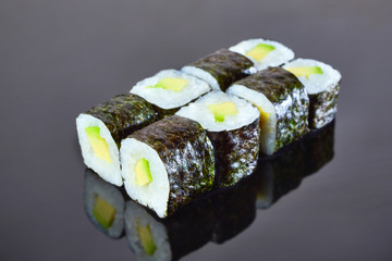 Classical vegan roll sushi with avocado on black background for menu. Japanese food