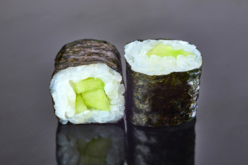 Classical vegan roll sushi with cucumber on black background for menu. Japanese food