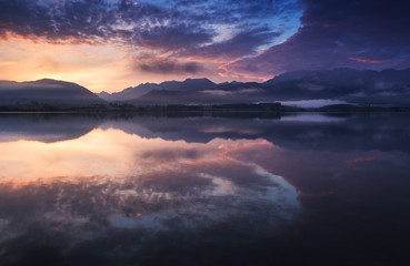 Sonnenaufgang mit farbenfrohen Wolken am Forggensee