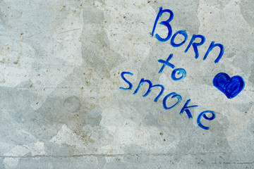 an inscription born to smoke on a gray metal surface