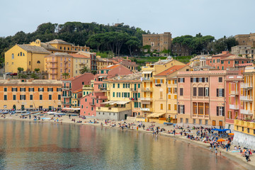 Fototapeta na wymiar High angle view of the Bay of Silence in the ancient fishing village of Sestri Levante with the typical colored houses and people on the beach in a sunny day, Liguria, Italy