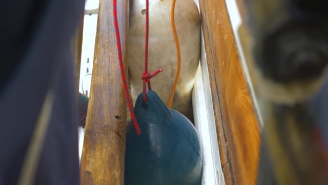 Adjusting fenders between two boats tied alongside each other in port