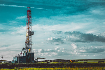 Land oil drilling rig in a green field