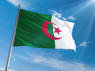 Algeria National Flag Waving on pole against sunny blue sky background. High Definition