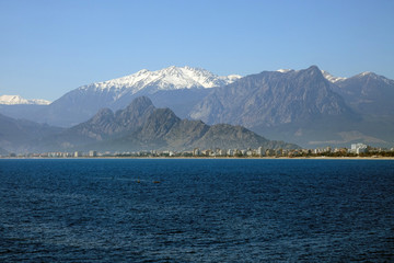 Fototapeta na wymiar Mediterranean sea and high mountains with snowy summit over clear blue sky in Antalya, Turkey