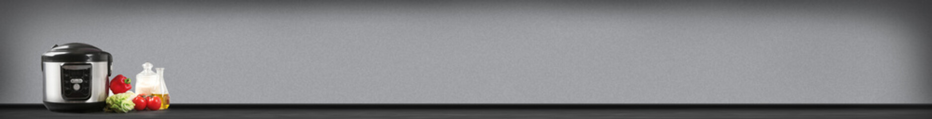 Modern electric multi cooker on table against color background. Space for text