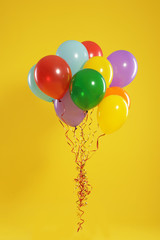 Bunch of bright balloons on color background. Celebration time