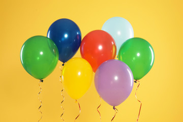 Bright balloons on color background. Celebration time