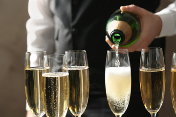 Waiter pouring champagne into glass, closeup view