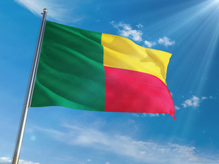 Benin National Flag Waving on pole against sunny blue sky background. High Definition