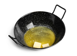 Frying pan with melting butter on white background