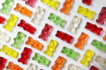 Many delicious little jelly bears on white background, top view