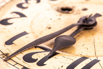 Antique clock with closeup pointer with time about twelve